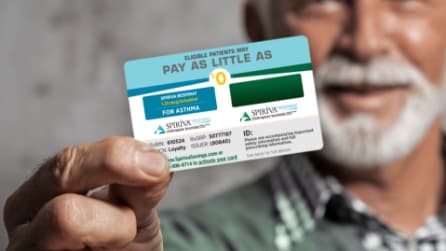 man holding SPIRIVA® RESPIMAT® savings card