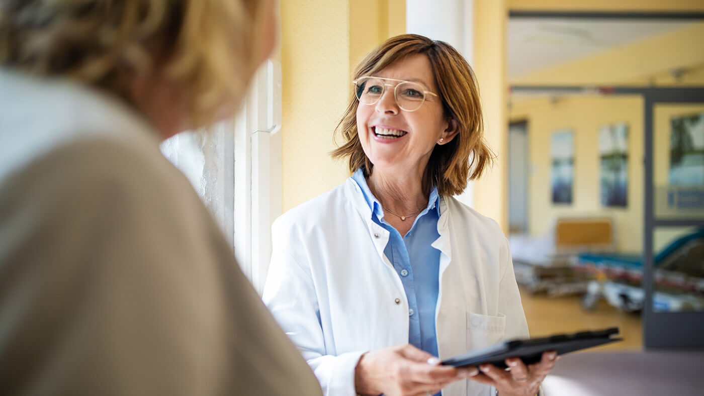 smiling physician holding a tablet